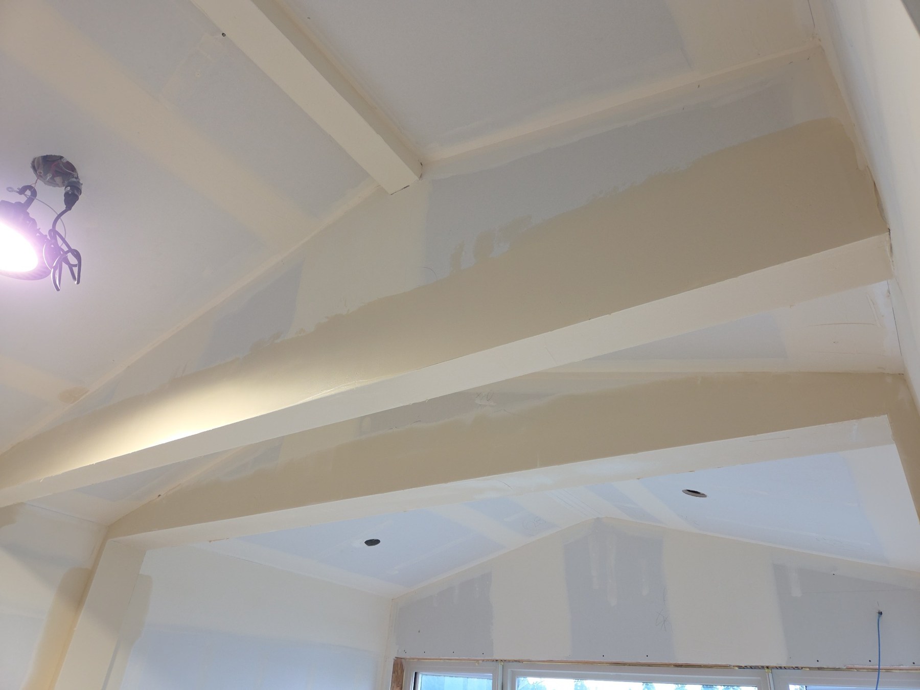 Top-coat work around ceiling planes and beams on a Class 5 smooth wall project in Bainbridge Island