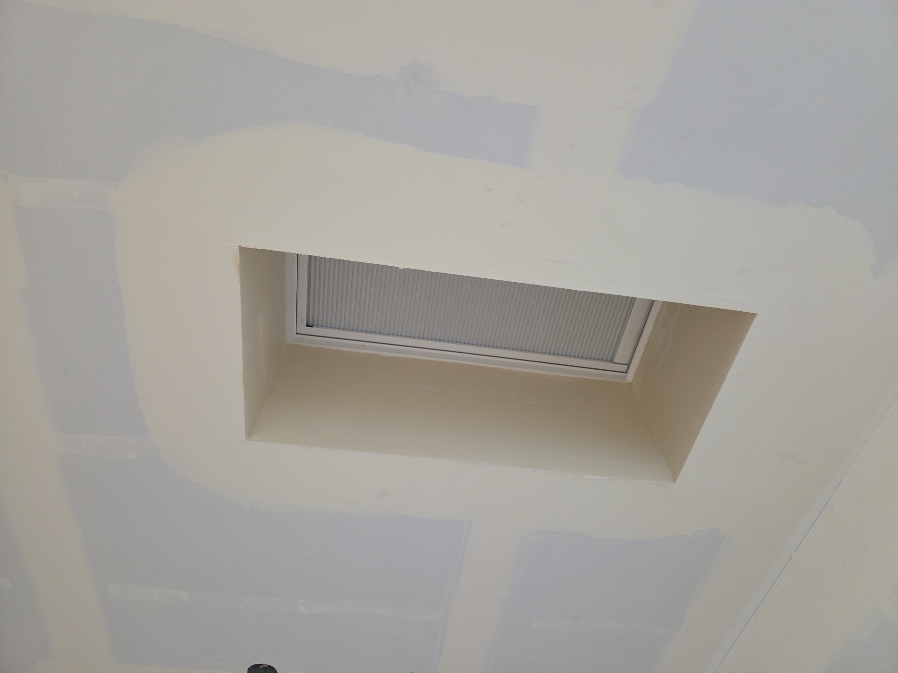 Top-coat work around a recessed skylight on a Class 5 smooth wall project in Bainbridge Island